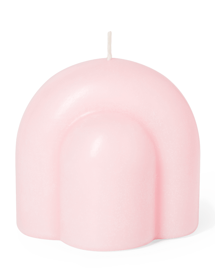 The Templo Candle by OCTAEVO is a pink, arch-shaped wax art piece with a single wick on a white background.