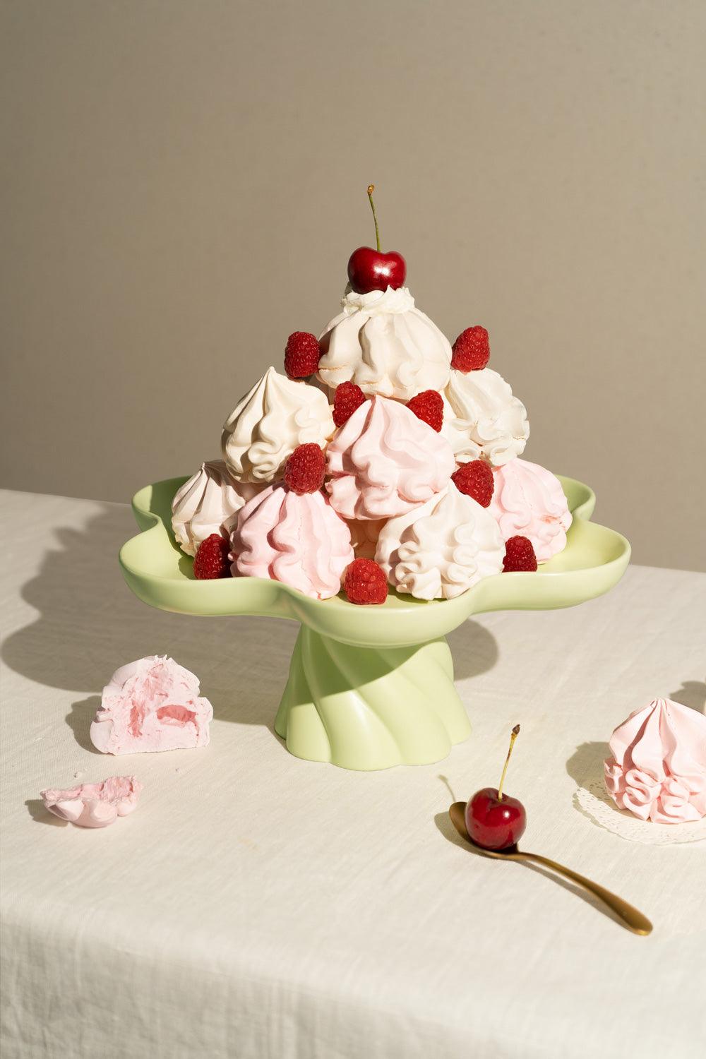A light mint Octaevo Templo High Tray displays pink and white meringues, raspberries, and cherries on a white cloth.