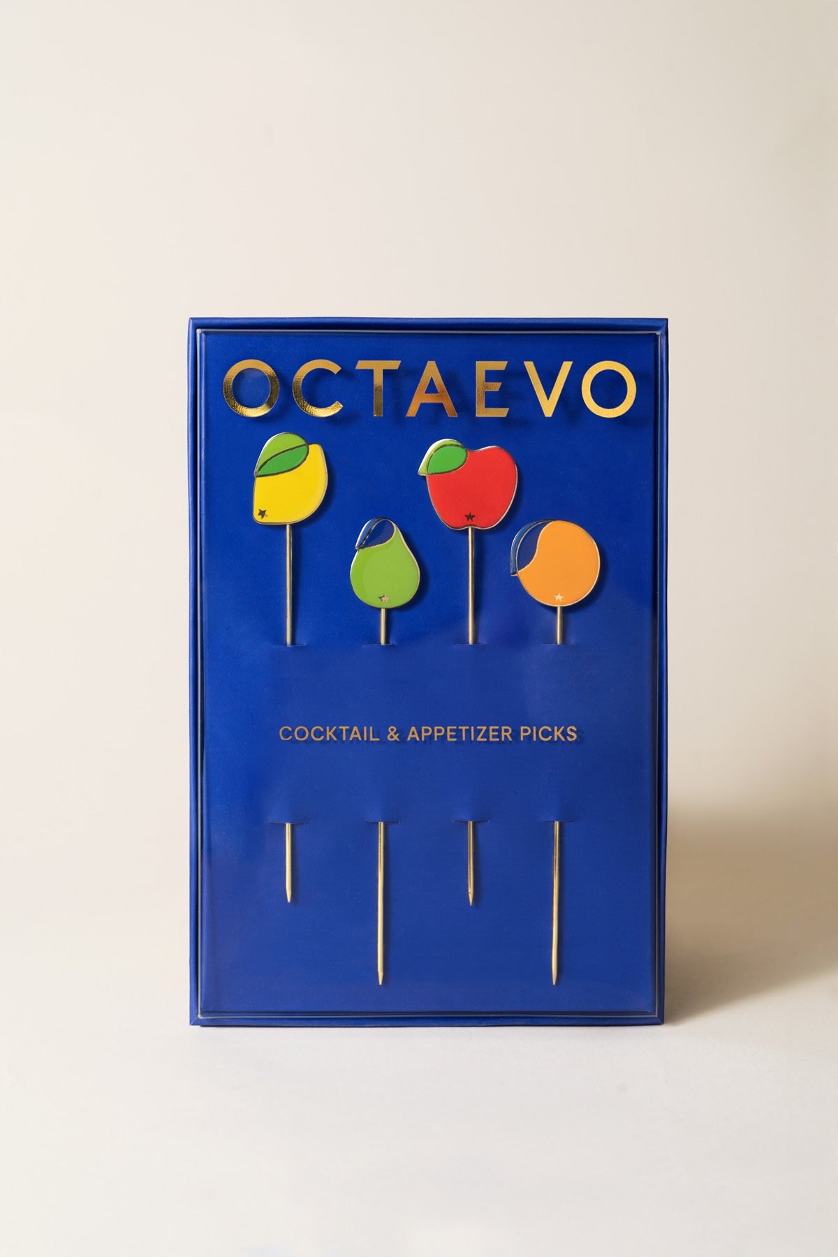 Octaevo Tutti Frutti Cocktail Picks (Set of 4) in a blue box; gold-plated and colorful for stylish entertaining.