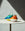 Colorful OCTAEVO Atlas Glass Bird sculptures sit on a round table, casting shadows under dramatic lighting.