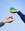 Two hands hold colorful Atlas Glass Birds against sky, each a vibrant decorative statement piece.