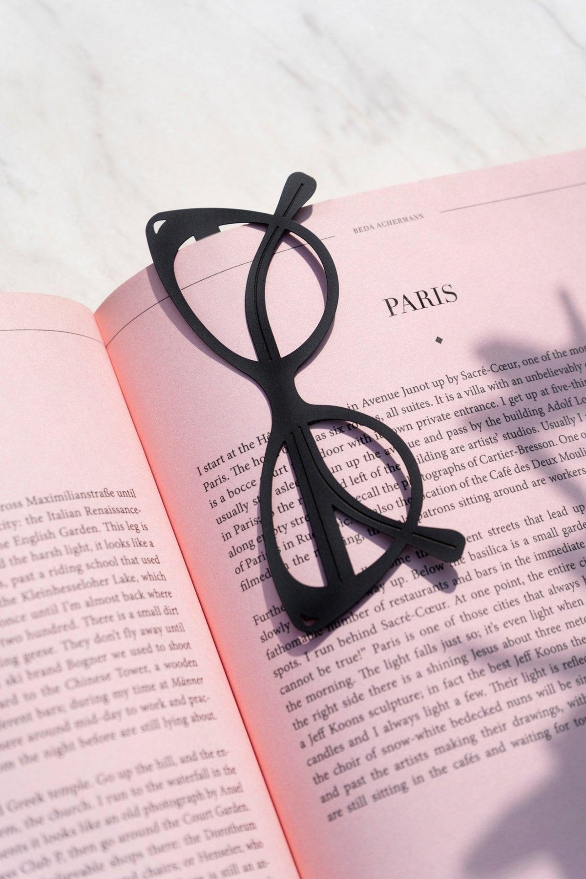 OCTAEVO Bookmark Dolce Vita—black stylish sunglasses bookmark on a pink book, a chic Mediterranean Riviera gift.