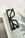 The black OCTAEVO Bookmark Plein Soleil, shaped like sunglasses, sits on an open book with text and an illustration.