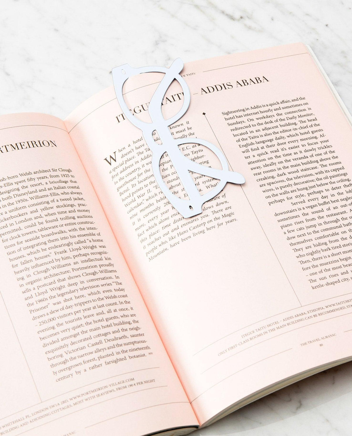 White OCTAEVO Bookmark Riviera rests on an open book with pink pages. 