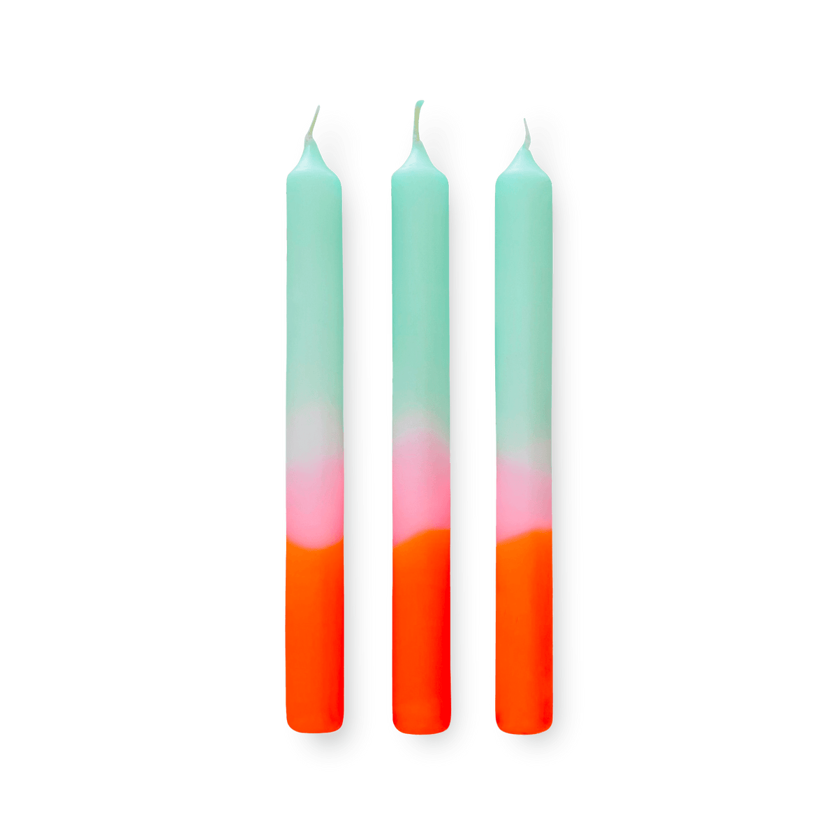 Three tall Dip Dye Candles Sorbet by Octaevo in blue, pink, and orange stand upright on a transparent background.