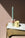 The Octaevo Flora Candle Holder in hand-glazed pink with a pastel blue candle sits beside a small yellow vase.