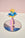 The Flower Paper Sculpture 2 by Octaevo stands on a mirror, evoking Elysian Fields beneath a pastel sky.