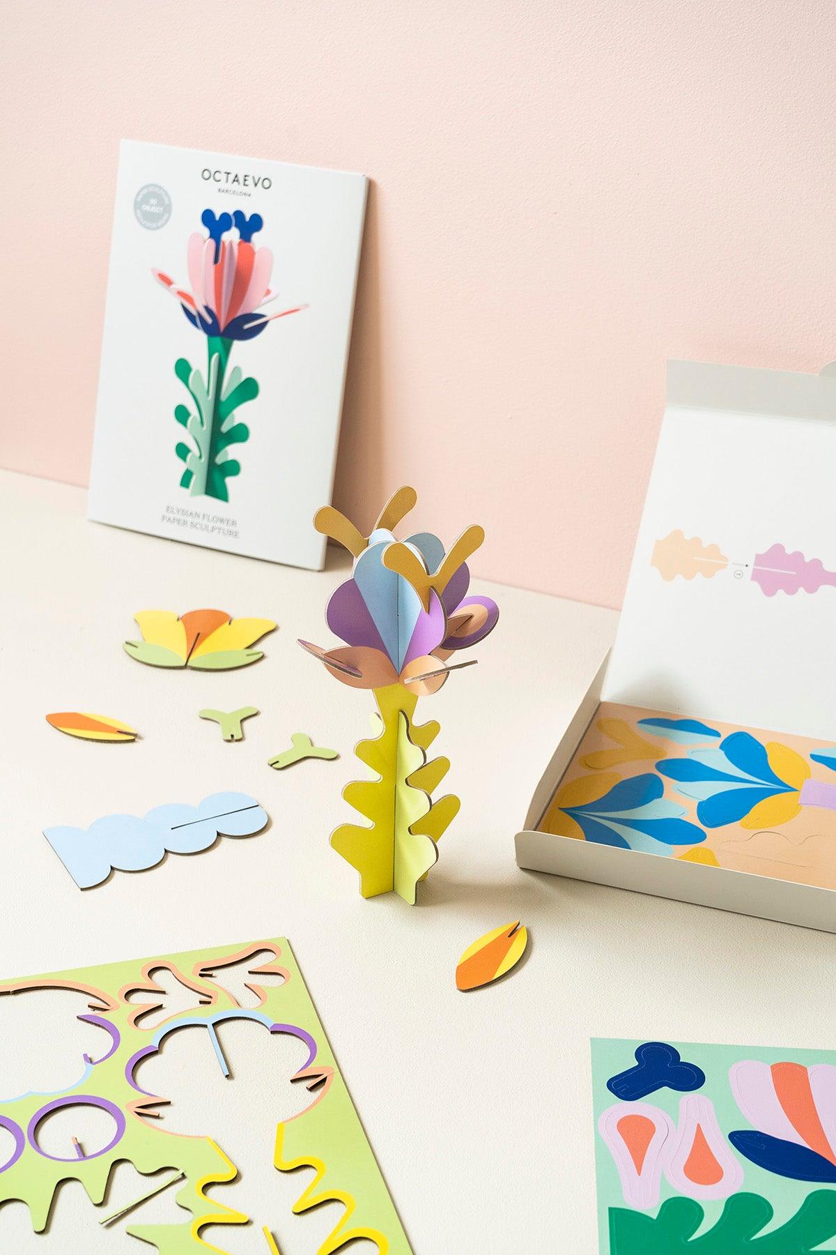 OCTAEVO Arcadia Flower Paper Sculpture kit features 3D flowers made from recycled paper on a beige and pink backdrop.