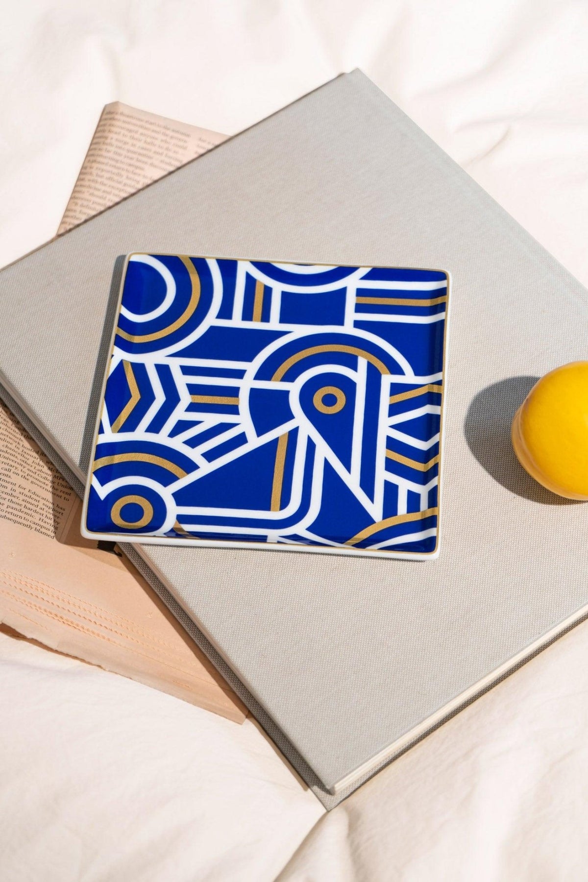 The Greco Ceramic Tray by OCTAEVO adds a bold, sophisticated touch as a bedside trinket next to books and decor.