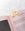 The OCTAEVO Greeting Card Bird gold metal bookmark sits on a pink book, ideal for pairing with your favorite cards.