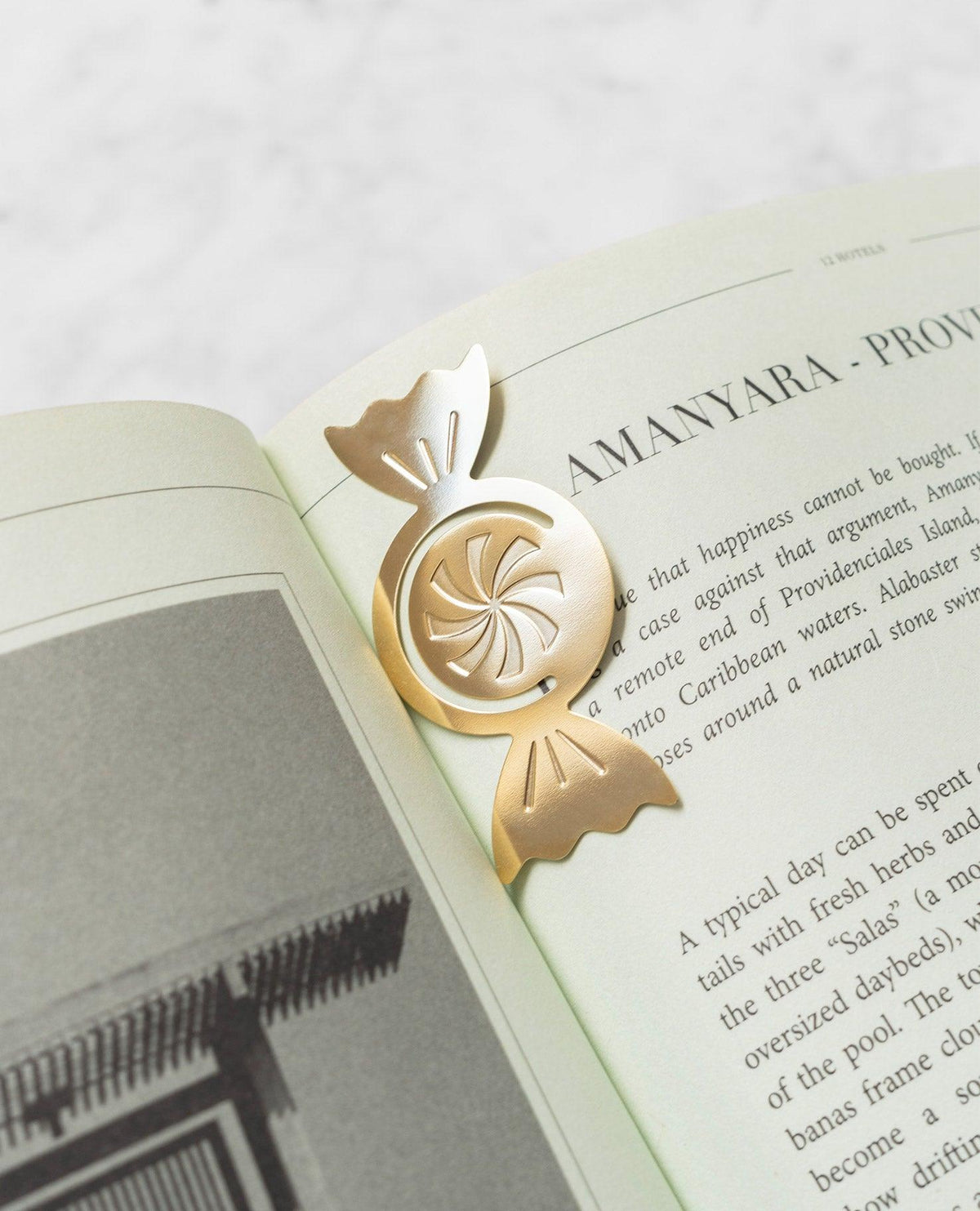 The OCTAEVO Greeting Card Candy, a gold candy-shaped clip, rests on an open book with text and a photo.