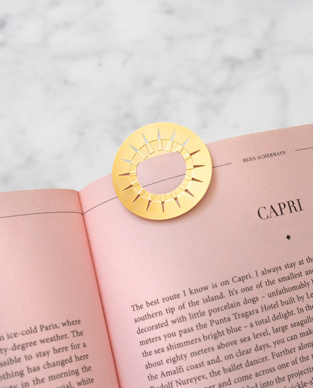 OCTAEVO Sun Greeting Card atop a marble surface, accented by a gold circular metal clip on a pink page.