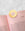 A gold sun-shaped metal bookmark on a pink book, perfect with OCTAEVOs Greeting Card Sun stationery.