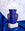 The Helio Paper Vase by OCTAEVO, in perforated blue, stands upright on a white block against blue and gray tones.