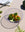Three heirloom tomatoes in a purple OCTAEVO Iris Wire Basket, on a table with vegetables and kitchen items.