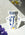 Limited edition Jaime Hayon Paper Vase by OCTAEVO, featuring a blue and yellow abstract face with blurred flowers nearby.