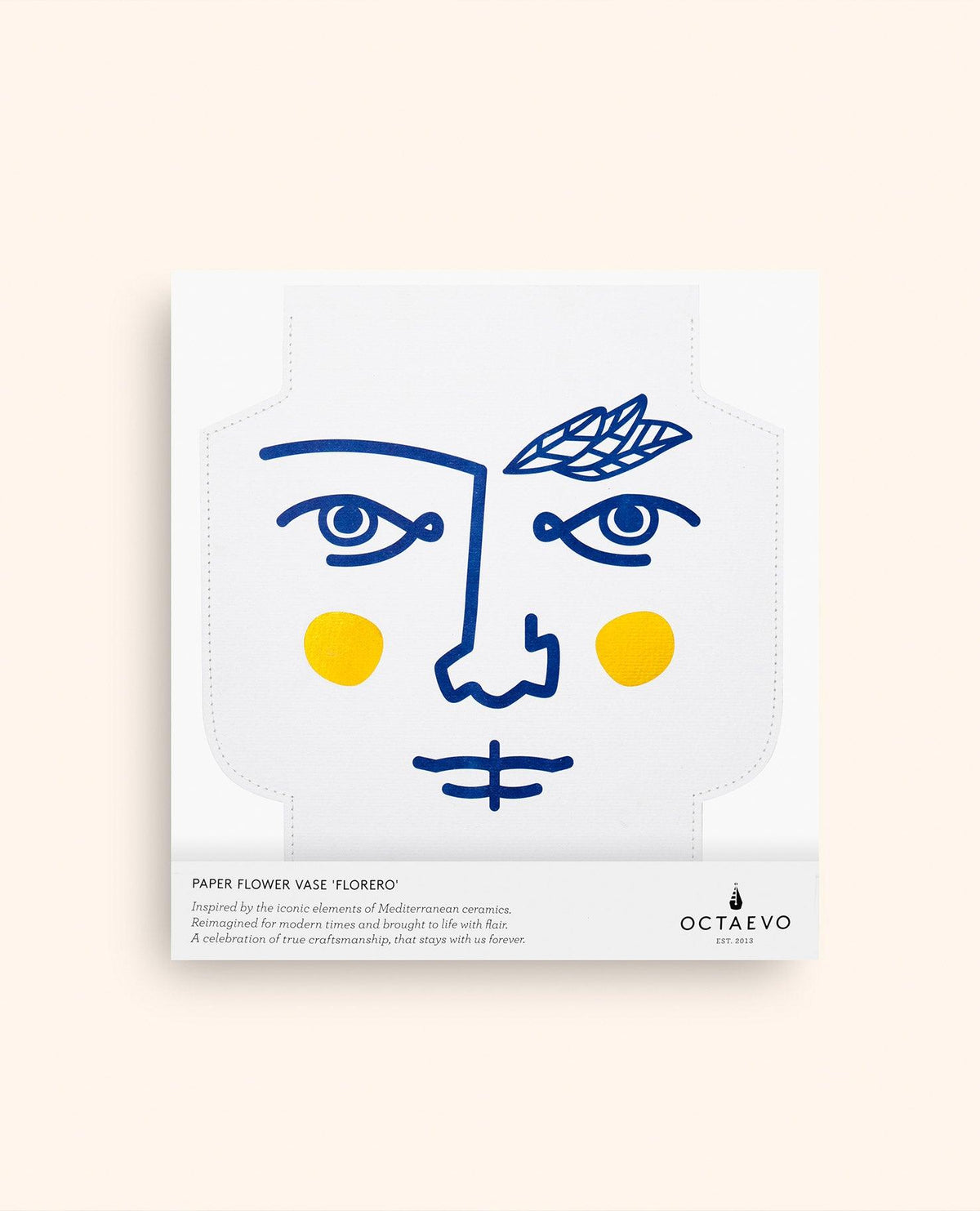 The Janus Paper Vase by OCTAEVO comes in white packaging with a blue face, laurel, and includes a waterproof vase inside.