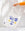 A hand holds OCTAEVOs Janus Tote Bag, a cotton bag with a blue face and gold cheeks on a light background.