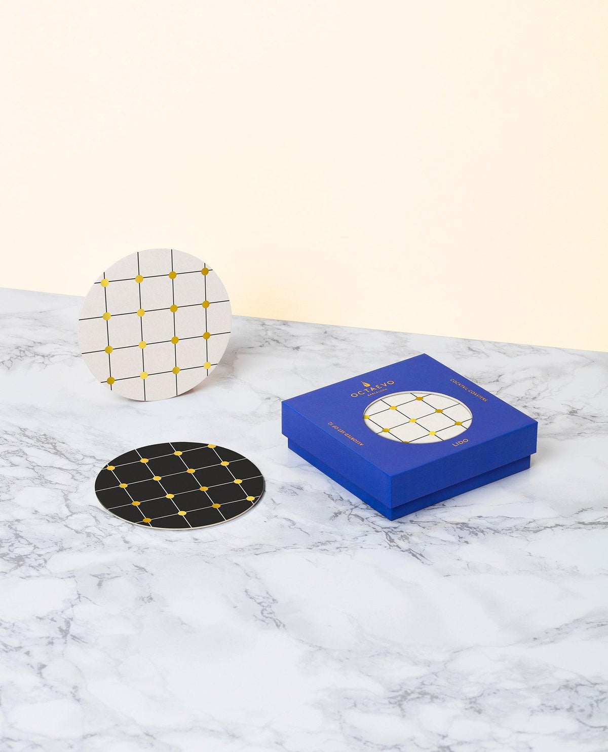 OCTAEVO Lido Cocktail Coasters feature grid patterns with gold foil, presented in a luxe gift box on marble.