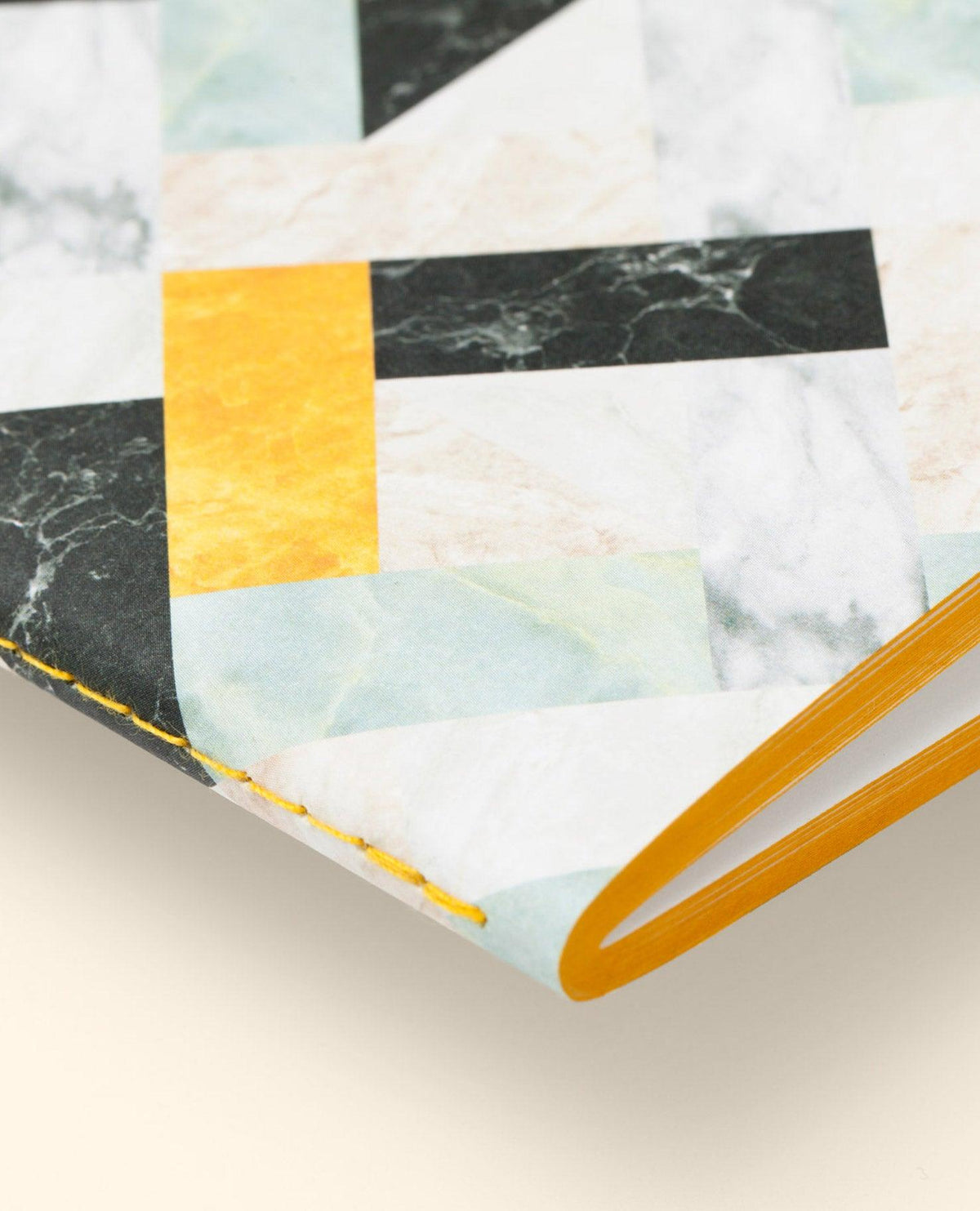 Marble Notes by OCTAEVO: hand-sewn artisan notebook with a geometric marble and yellow pattern on beige.