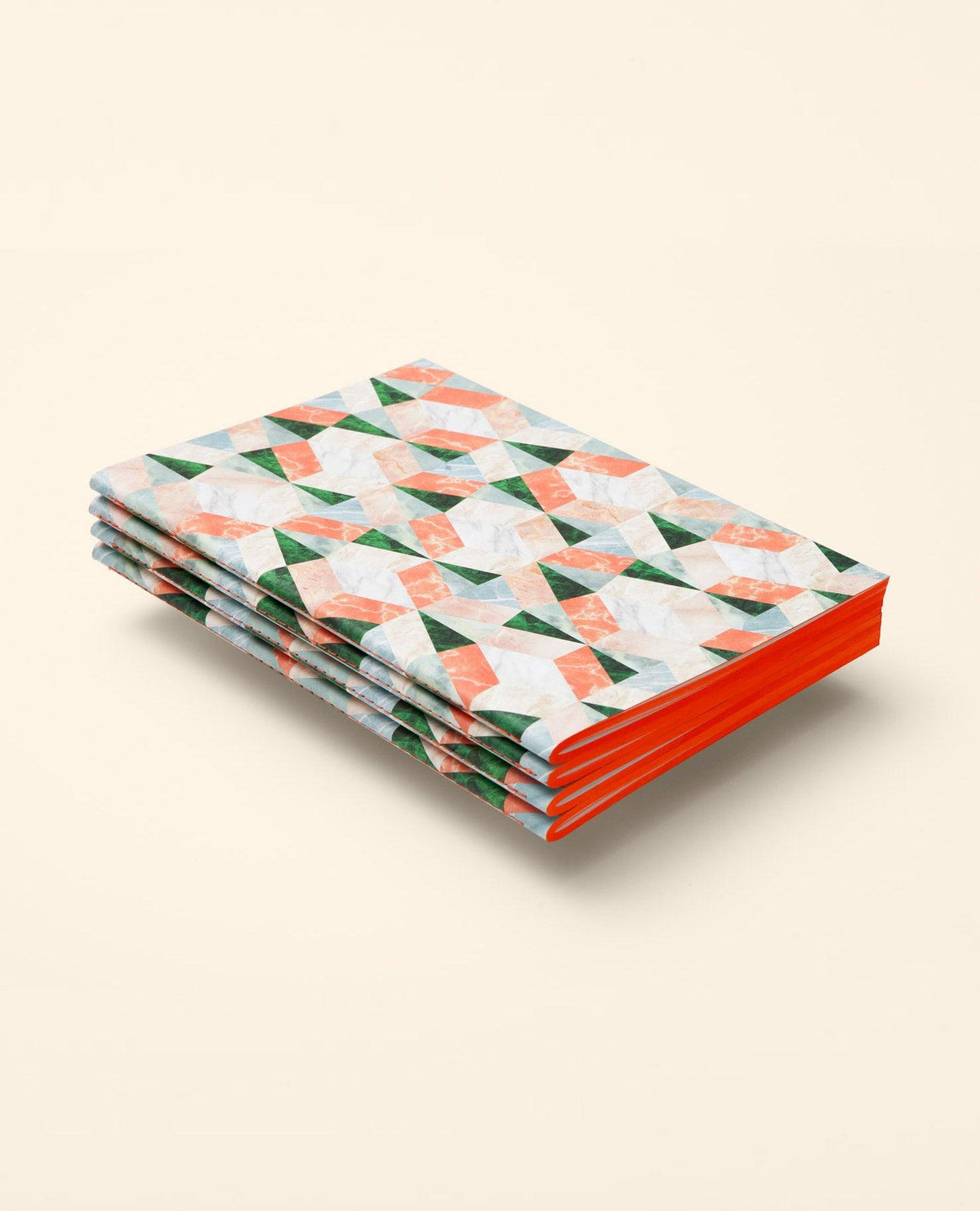 Three OCTAEVO Marble Notes notebooks with colorful geometric covers and red spines stacked on a beige surface.