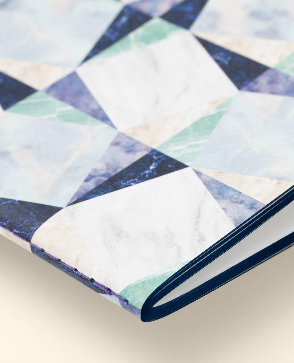 Close-up of OCTAEVO Marble Notes, an artisan notebook with a blue, green, and white marble geometric cover.