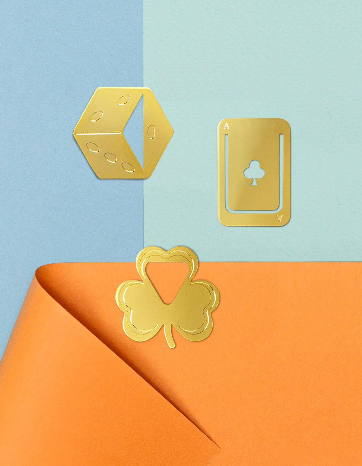 OCTAEVO Metal Clips Fortuna: gold die, ace of clubs, and shamrock clips accent blue and orange paper decoratively.