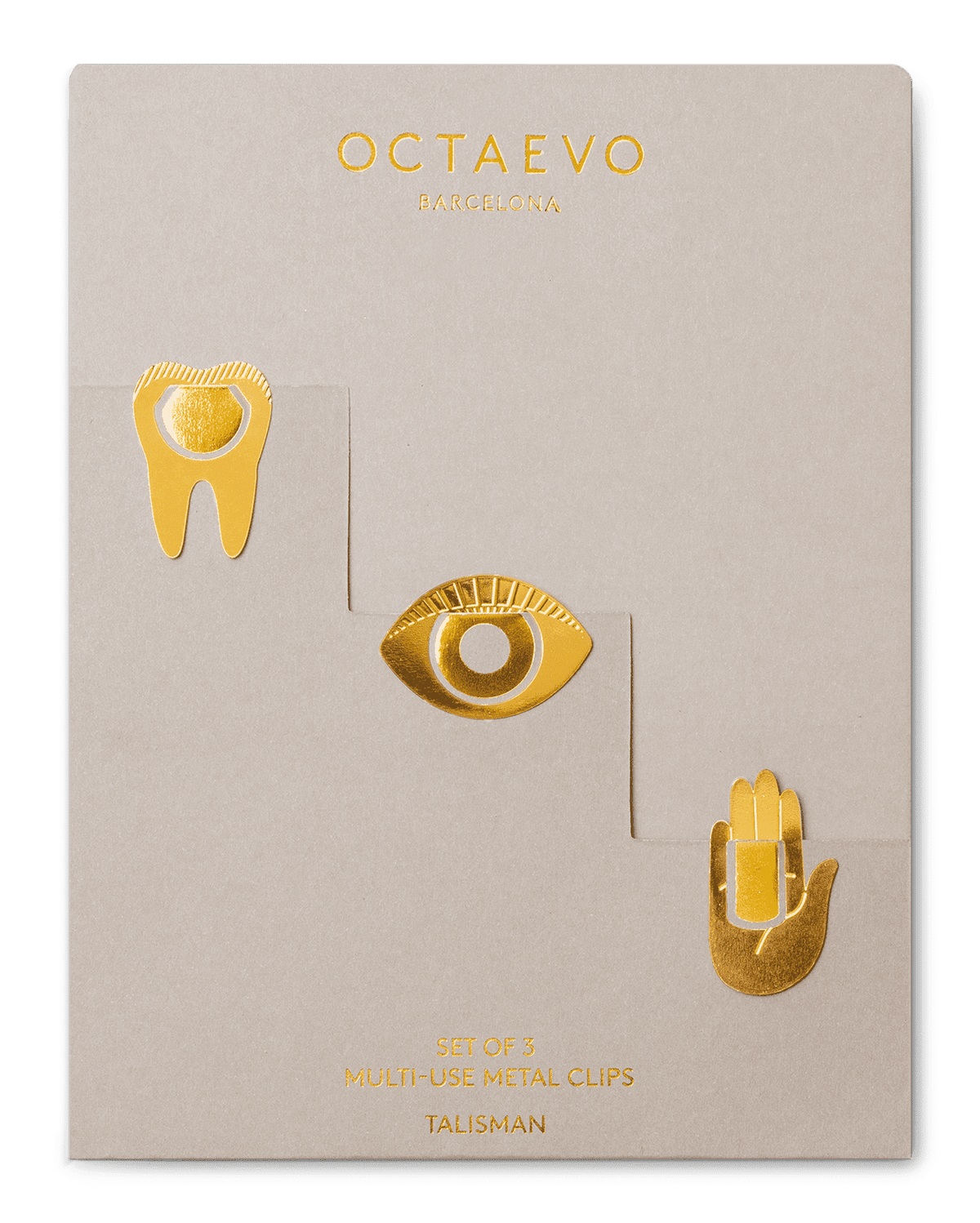 Set of three Metal Clips Talisman by OCTAEVO—shaped as a tooth, eye, and hand—on beige packaging.
