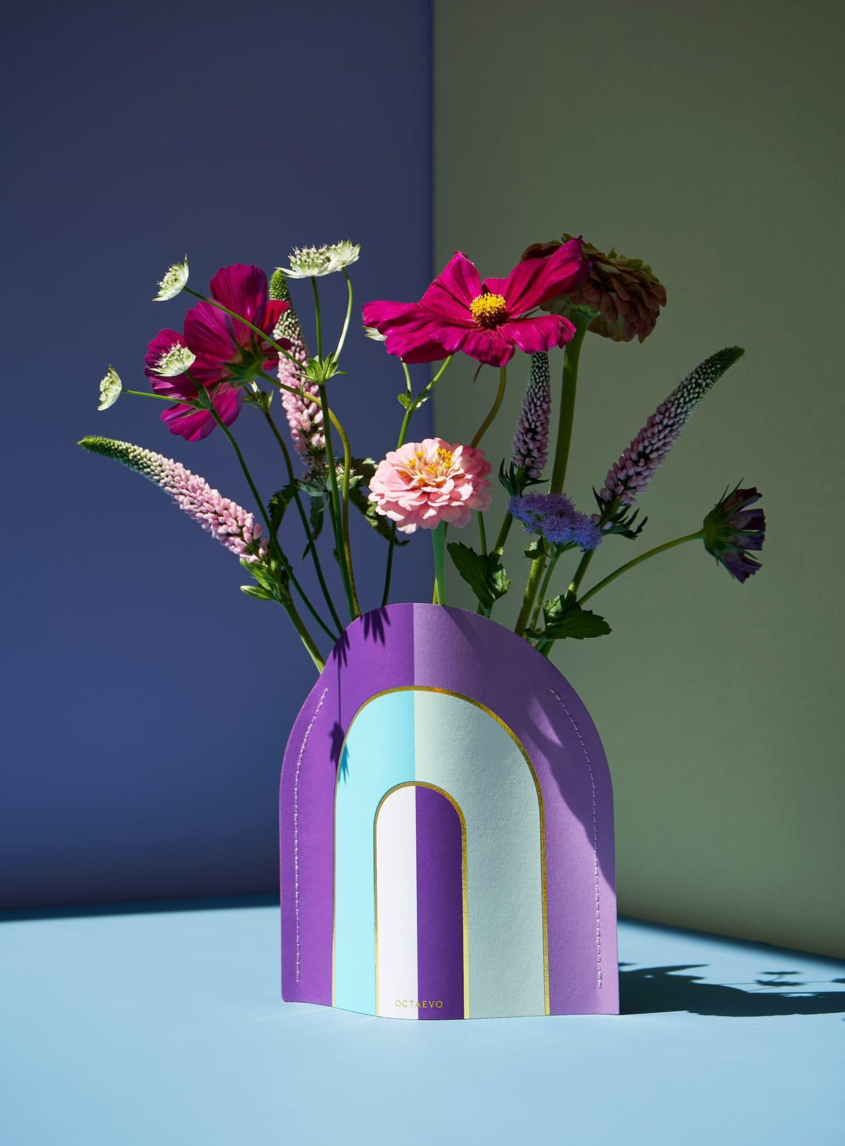 A Mini Paper Vase Riviera Arch by OCTAEVO creates a vibrant statement on a pastel background.