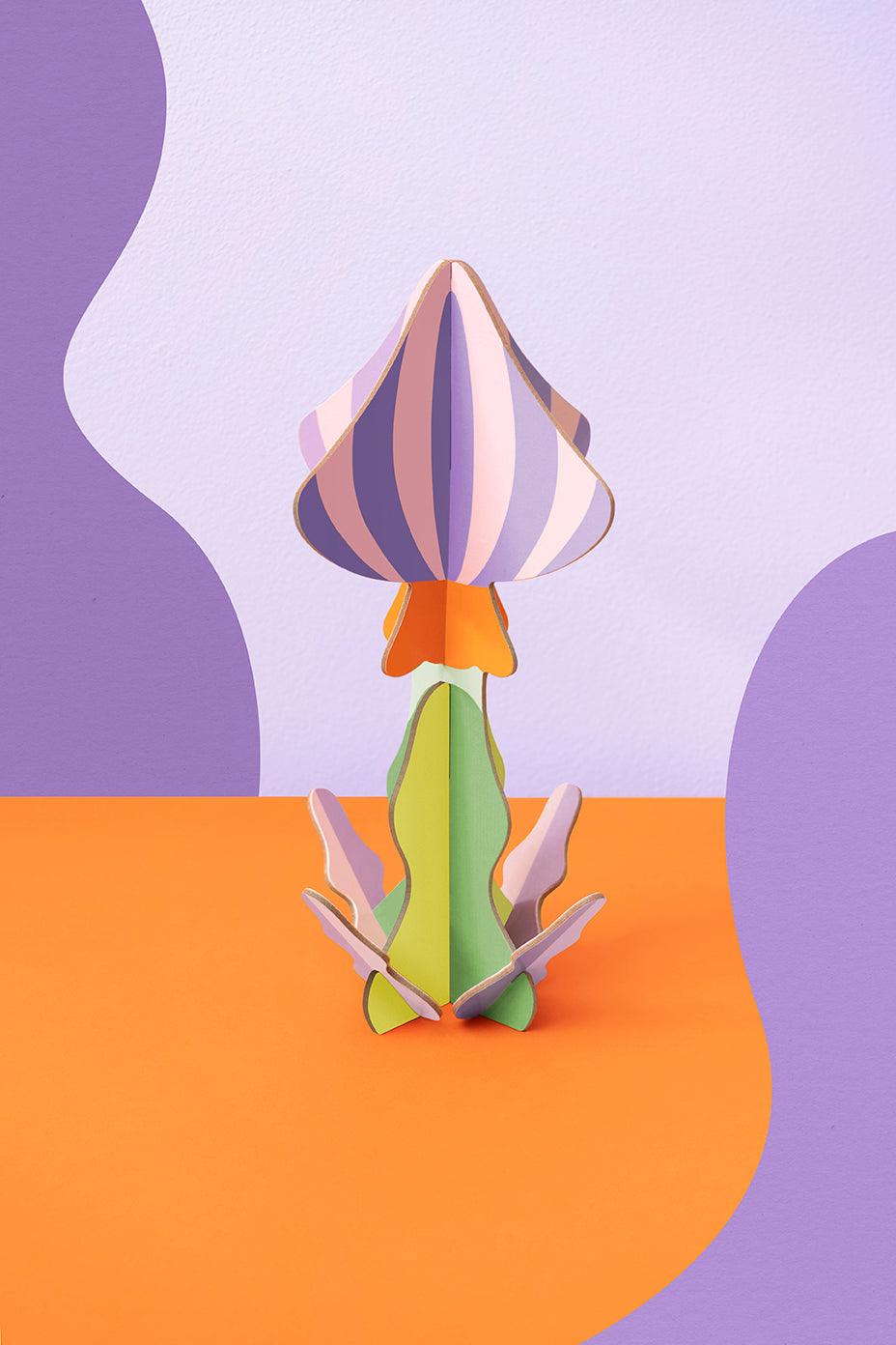 OCTAEVO Woodland Mushroom Paper Sculpture—crafted from recycled cardboard for vibrant home décor on a wavy backdrop.