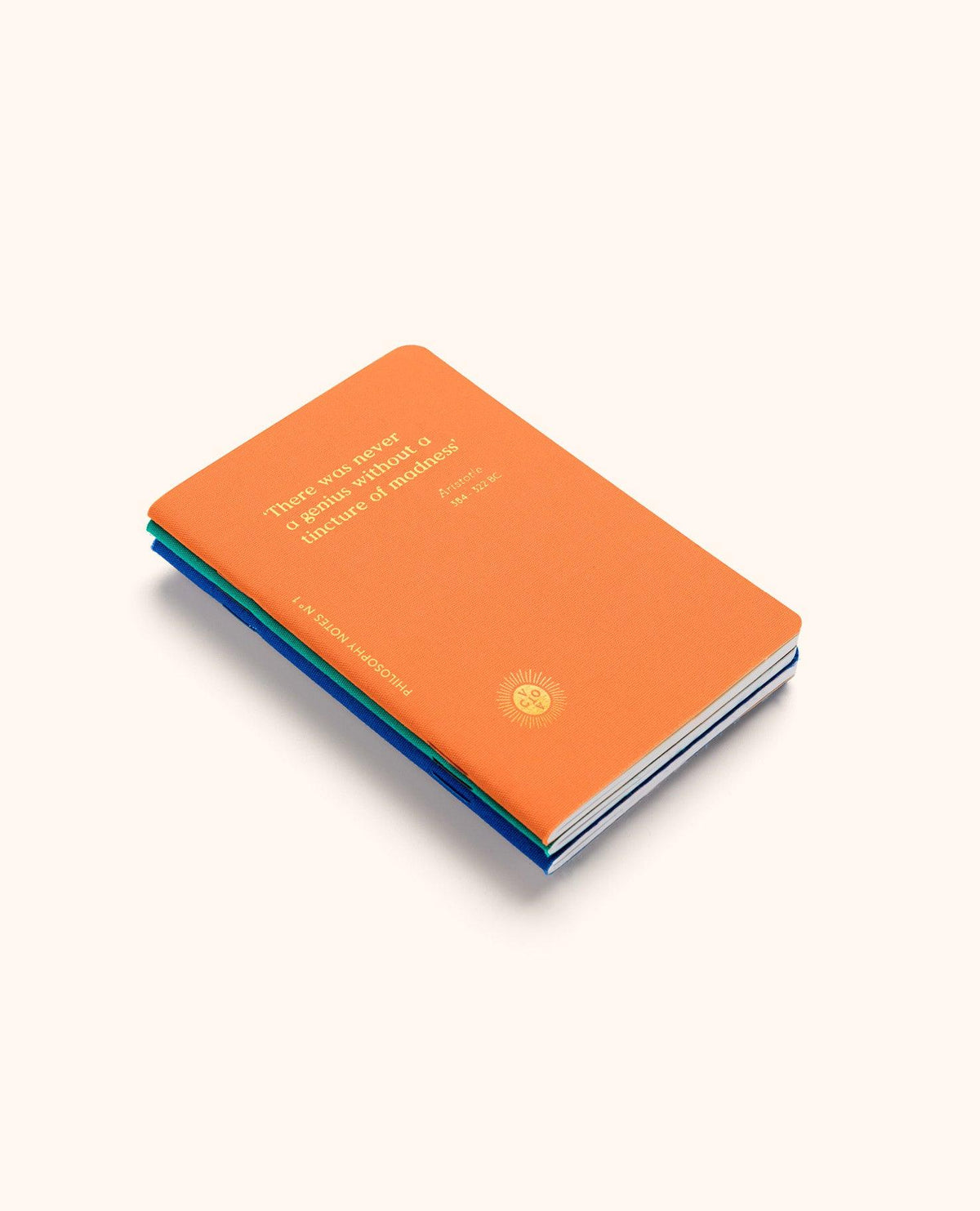 An orange Philosophy Passport Notes by OCTAEVO, with gold lettering, stacked on two others from the box of three.