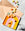 Colorful candies on the orange OCTAEVO Riviera Ceramic Tray, scattered on a peach paper and marble table. 