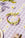 The OCTAEVO Sicilia Ceramic Trivet rests on a purple gingham tablecloth beside decorative wreath accents.