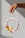 A hand holds the pink OCTAEVO Sicilia Ceramic Trivet, perfect as earthenware wall decor against a light gray background.