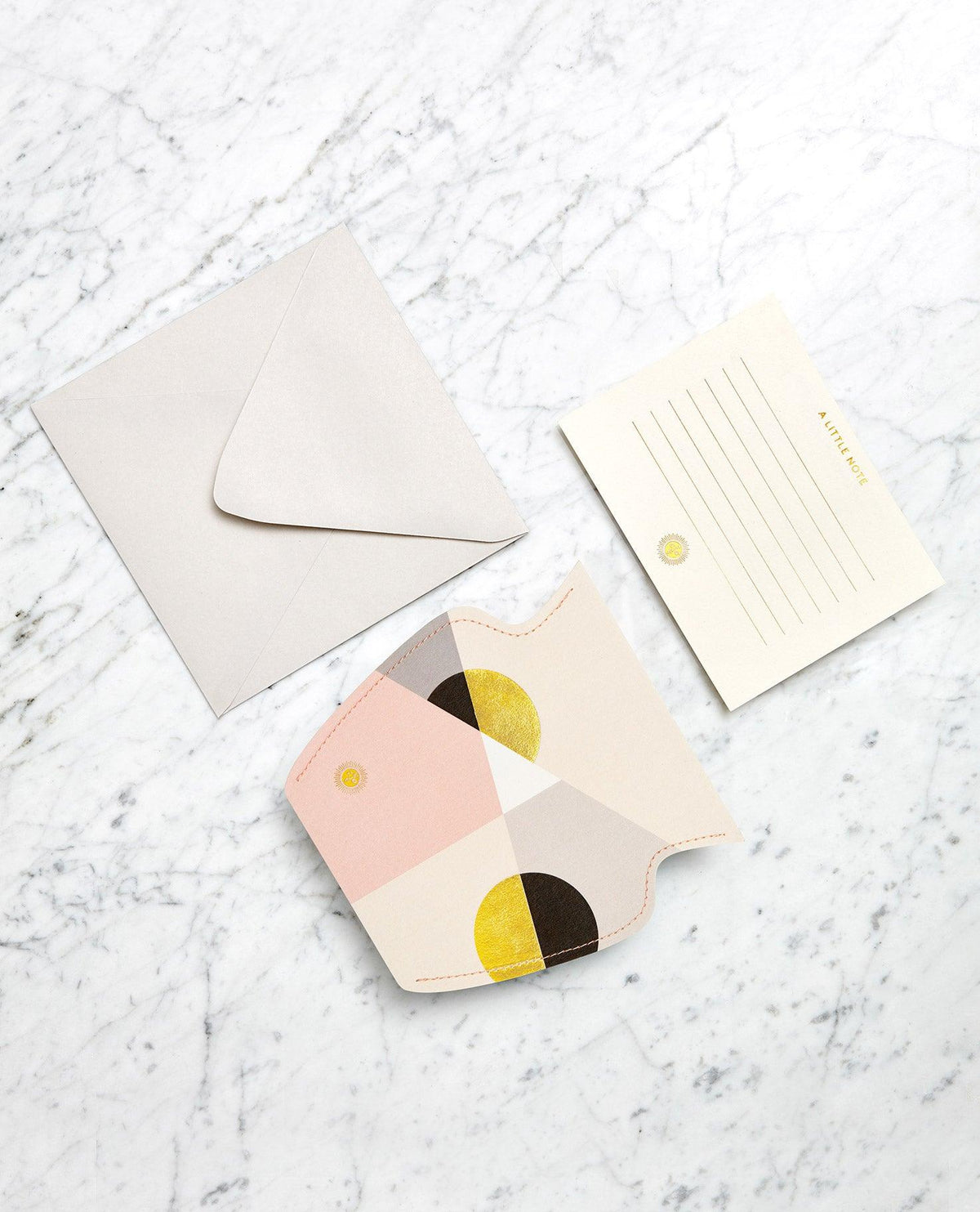 A blank card, envelope, are beside a pink OCTAEVO Siena Mini Paper Vase on a marble surface.