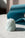 The Octaevo Templo Candle, a twisted pale blue artisan piece, sits on white marble with blue paper in the background.