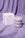 The OCTAEVO Templo Candle, a round stacked design, is shown with its box on lilac fabric.