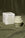 The Templo Candle by OCTAEVO, in hand-poured wax, is shown with its white box on olive green fabric.