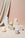 The Templo Candle by OCTAEVO features pastel, hand-poured wax in relic shapes, displayed on draped white boxes.