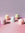 Five pastel Templo Candles by OCTAEVO, hand poured in abstract shapes, rest on a pink surface with a purple background.