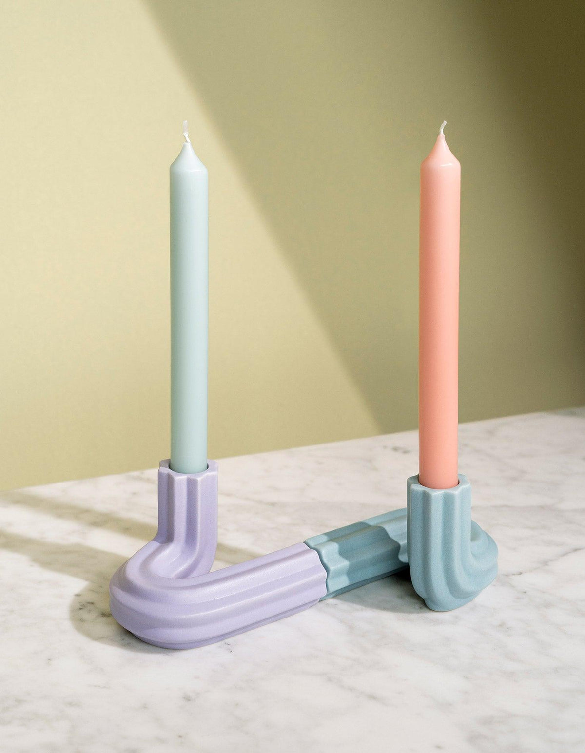 Pastel candles in the purple OCTAEVO Templo Candle Holder on marble, softly lit for a chic touch.