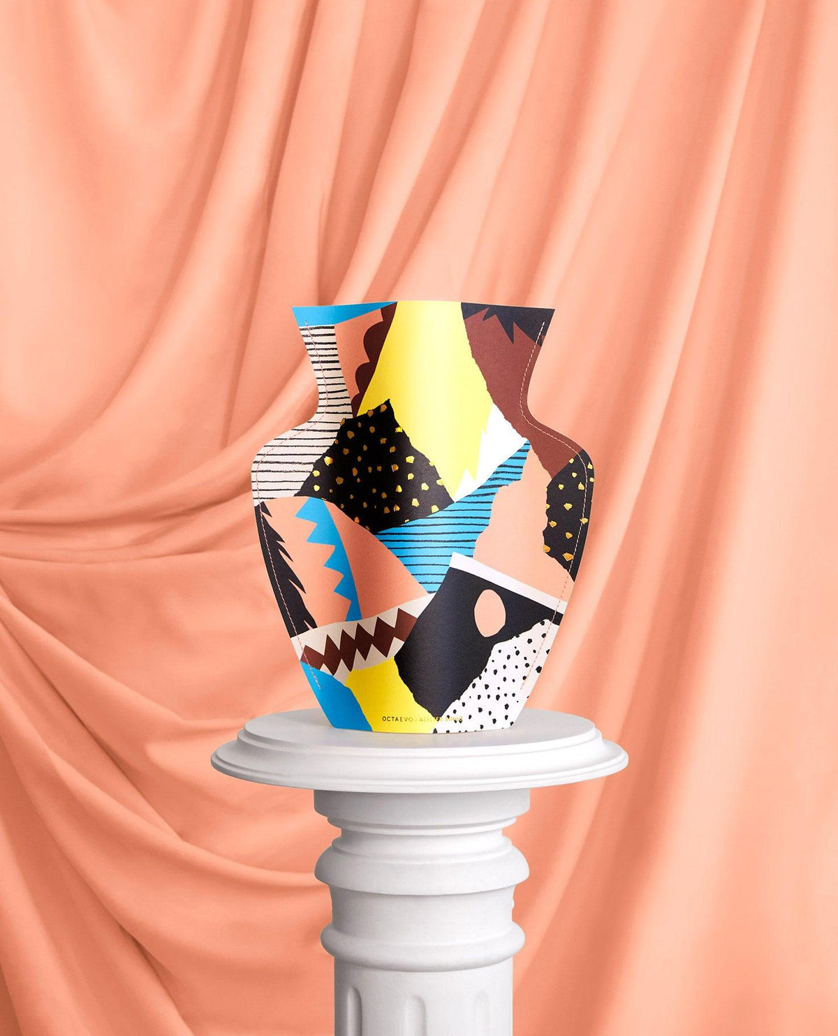 The Vesuvio Paper Vase by OCTAEVO sits on a pedestal, a vibrant abstract piece ideal as an original gift.
